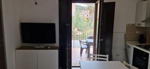 a kitchen with a television and a kitchen with a balcony at Arbatax Apartment in Àrbatax