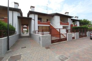 a house with red and white walls and a driveway at Regina Mare in Lido degli Scacchi