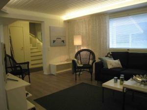 a living room with a black couch and chairs at Villa Rusinlahti, private beach in Pieksamaki +37 photos
