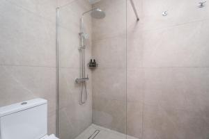 Modern seaview apartment in the heart of Agia Napa في أيا نابا: حمام مع دش وباب زجاجي +21 صورة