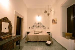 a bedroom with a bed and a mirror and a dresser at Mesón del Alcalde in Lagos de Moreno