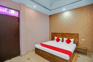 a bedroom with a bed with red pillows at Hotel O Shri Nanadan Palace in Kānpur +22 photos