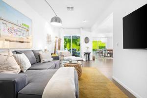 Una sala de estar con un sofá y un televisor. en Paseo Passing Luxe Palm Desert Pool Home Firepit, en Palm Desert