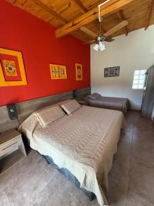 a bedroom with a bed and a red wall at La Puerta de Cachi in Cachí