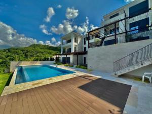 a house with a swimming pool next to a building at Magic view - Apartment with Pool in Budva