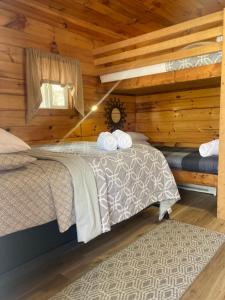 a bedroom with two beds in a log cabin at Campfire Cabin, Red River Gorge, KY, River Access & Views in Stanton