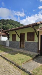 une maison avec des portes en bois sur le côté dans l'établissement Casa da Vila, Charme e Conforto no Coração de Visconde de Mauá, à Visconde de Mauá