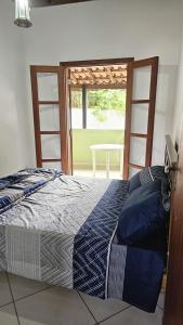 - une chambre avec un lit et une fenêtre avec une table dans l'établissement Casa da Vila, Charme e Conforto no Coração de Visconde de Mauá, à Visconde de Mauá