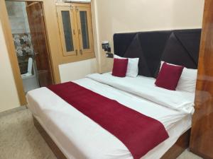 a bedroom with a large bed with red and white pillows at Golden Bar And Hotel in Sandīla