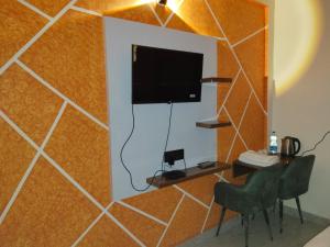 a room with a tiled wall with a flat screen tv at Golden Bar And Hotel in Sandīla