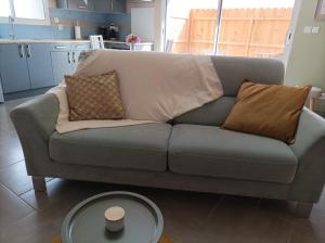 a gray couch with pillows and a table in a living room at " L'instant Nid d'où " , Spa et Luxe Intime in Baneuil