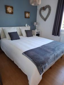 a large white bed with a blue blanket on it at LA CLOSERIE D'ISABAULT in Eu
