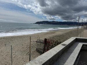 a sandy beach with a fence and the ocean at Psalm 23 in Savona