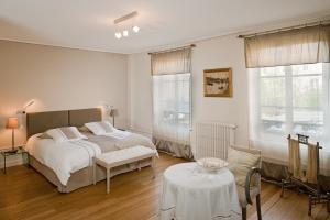 a bedroom with a bed and a table and two windows at Maison d'Hôte de Myon in Nancy