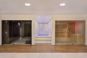Habitación con 2 puertas de cristal y ducha a ras de suelo. en Hilton Malta, en San Julián