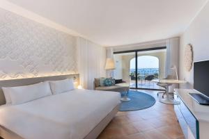 Una habitación de hotel con una cama y una sala de estar. en Hilton Malta, en San Julián