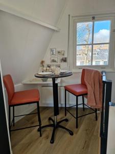 a table and two chairs in a room with a window at Bed & Breakfast De Punt in Monnickendam