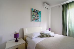 - une chambre blanche avec 2 lits et une lampe violette dans l'établissement La casina dei Praticelli, à Castelfiorentino 23 autres photos