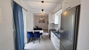 a kitchen with a table and some blue chairs at Karpathos View Luxury Apartment in Karpathos