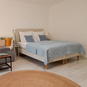 a bedroom with a bed with blue and white pillows at Marilla Apartman in Tata
