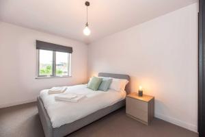 ein Schlafzimmer mit einem Bett, einem Nachttisch und einem Fenster in der Unterkunft Cozy 2 Bedroom Waterloo London Bridge in London