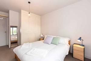 ein Schlafzimmer mit einem großen weißen Bett mit zwei Kissen in der Unterkunft Cozy 2 Bedroom Waterloo London Bridge in London + 4 Fotos