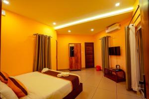a hotel room with a bed and a television at Ginberry Holidays in Wayanad +38 photos