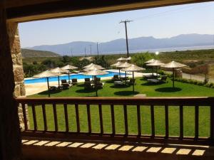 a balcony with a view of a pool with umbrellas at Simosmare Resort in Elafonisos