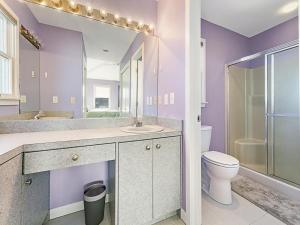 un bagno viola con lavandino e servizi igienici di Ocean Side, Beach Badges, Wifi, Brant Beach,4 Bedroom Beach House, Steps To The Sand 13113 a Brant Beach Altre 25 foto