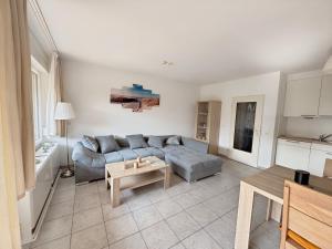 a living room with a couch and a table at Deich&Düne Nordsee -Apartment in Schillig