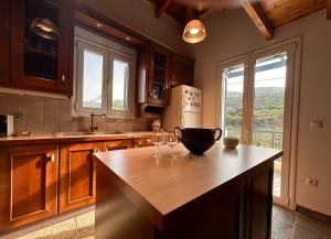 a kitchen with a counter with wine glasses on it at VISTA MARE Kythera House in Agia Pelagia