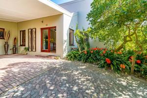 een huis met een oprit en bloemen ervoor bij 5 on Paul Kruger in Somerset West