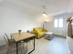 a living room with a table and a yellow couch at Lacasitadevaleria in Santander