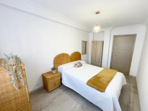 a bedroom with a white bed with a yellow blanket at Lacasitadevaleria in Santander