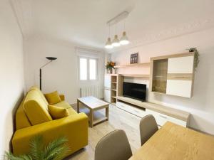a living room with a yellow couch and a table at Lacasitadevaleria in Santander