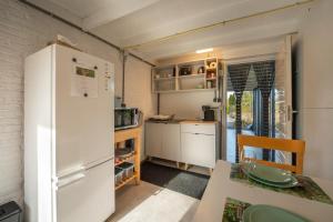 una piccola cucina con un frigorifero bianco e un tavolo di Studio ZEEUWS KNOOPJE a Burgh Haamstede Altre 26 foto