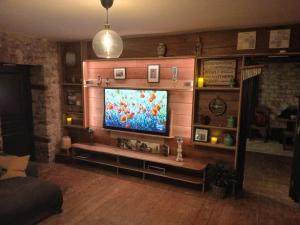 a living room with a flat screen tv on a wall at Manoir La Cerise in Fougerolles