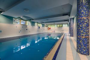 a large swimming pool in a building at Apartament W Dolinie Słońca z ogródkiem & SPA in Kościelisko