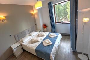 a bedroom with a bed with two towels on it at Travel Concept - Silver Mountain in Poiana Brasov