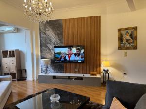 a living room with a flat screen tv on a wall at Classic Style 3 bedrooms Zamalek apartment in Cairo