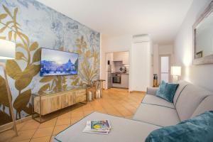 a living room with a couch and a tv on a wall at Domus Regola Luxury Apartment in Rome