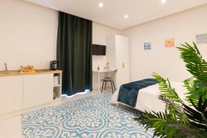 a bedroom with a bed and a kitchen and a table at Via Roma Suites in Ischia Town