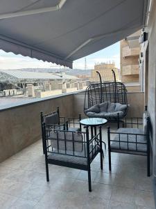 a balcony with two chairs and a table and a window at Prime apartment in Buzand 17 with beautiful terrace in Yerevan +6 photos