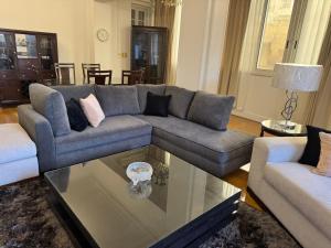 a living room with a couch and a glass table at Classic Style 3 bedrooms Zamalek apartment in Cairo