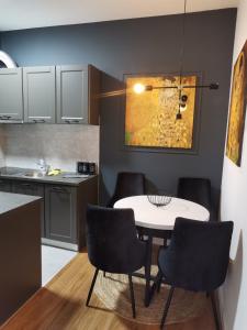 a small kitchen with a white table and chairs at Royal apartman Banja Luka in Banja Luka