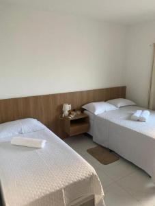 a bedroom with two beds and a table at William santos Garcia in Natal +15 photos