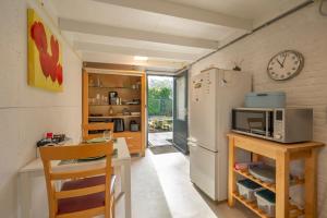 una cucina con frigorifero e un tavolo con forno a microonde di Studio ZEEUWS KNOOPJE a Burgh Haamstede