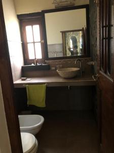 een badkamer met een wastafel, een toilet en een spiegel bij Lagriega in Cuesta Blanca