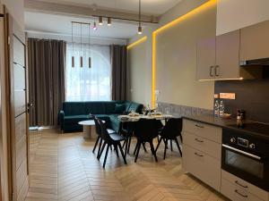 a kitchen and living room with a table and a couch at Apartament Kalina - Wyszyńskiego in Świeradów-Zdrój +29 photos