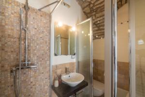 a bathroom with a sink and a glass shower at La Vecchia Torre in Bosa